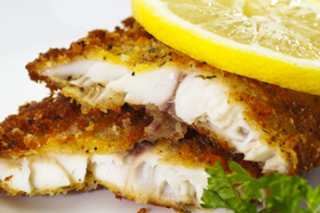 Baked Halibut sliced and topped with fresh lemon
